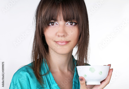 Young woman with a drinking bowl on white background