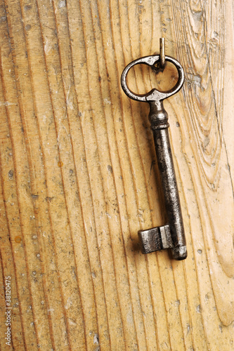 old key on a wooden background © stokkete