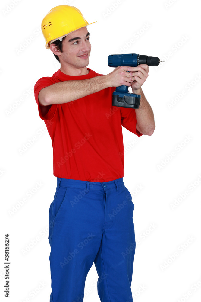 Young laborer using drill Young laborer using drill