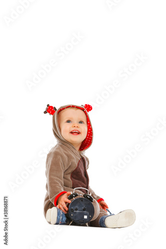 Baby in costume of Santa Claus's reindeer with alarm clock