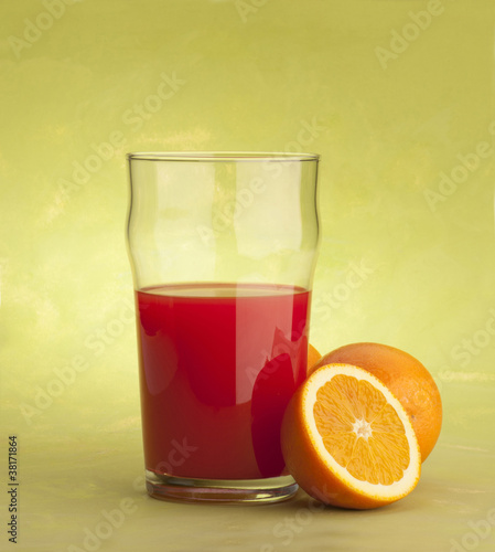 orange juice with oranges on green background