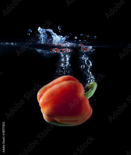 Red paprika splashing into water