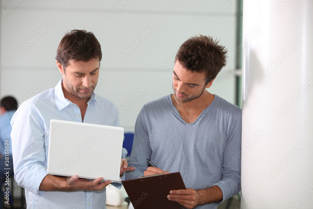 Colleagues looking at a laptop computer Colleagues looking at a laptop computer