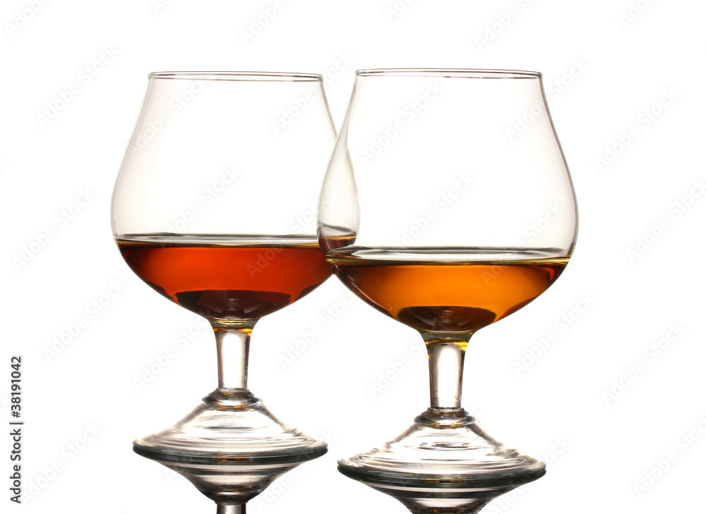 Two glasses of cognac on grey background Two glasses of cognac on grey background