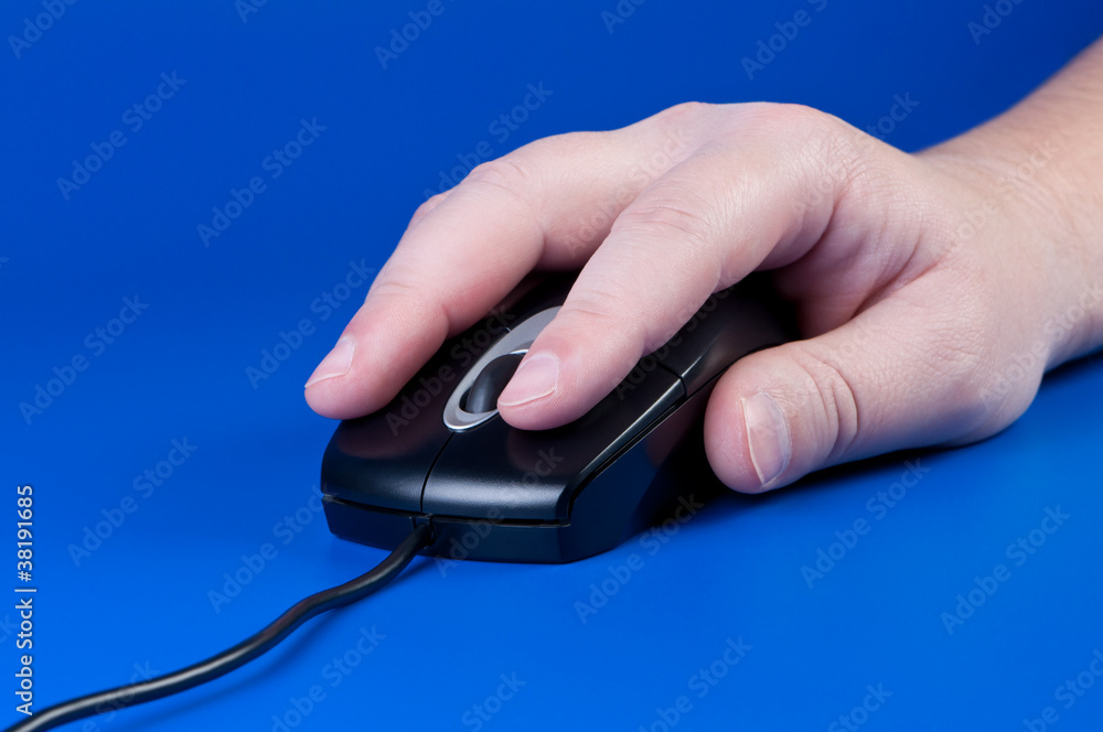 Hand with computer mouse on blue background. Hand with computer mouse on blue background.