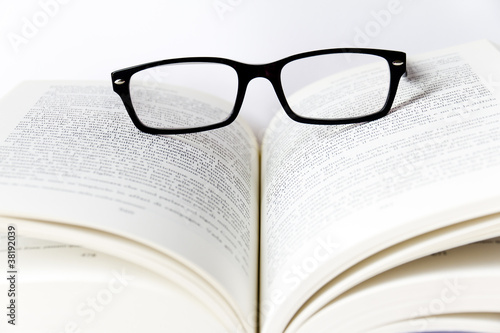 Libro aperto con occhiali da vista