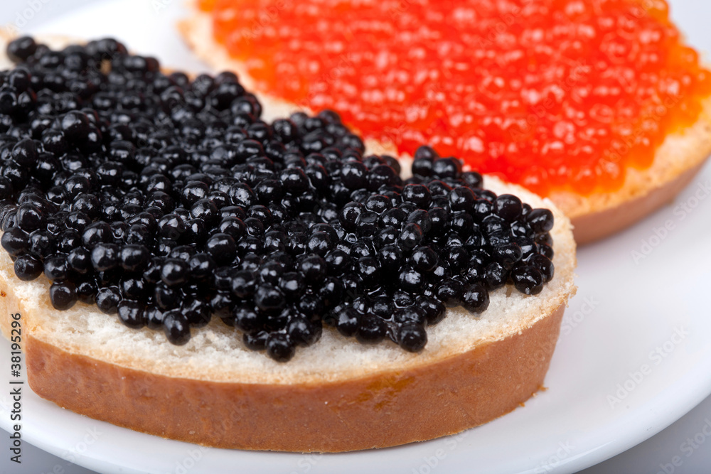 two sandwichs with red and black caviar on plate two sandwichs with red and black caviar on plate