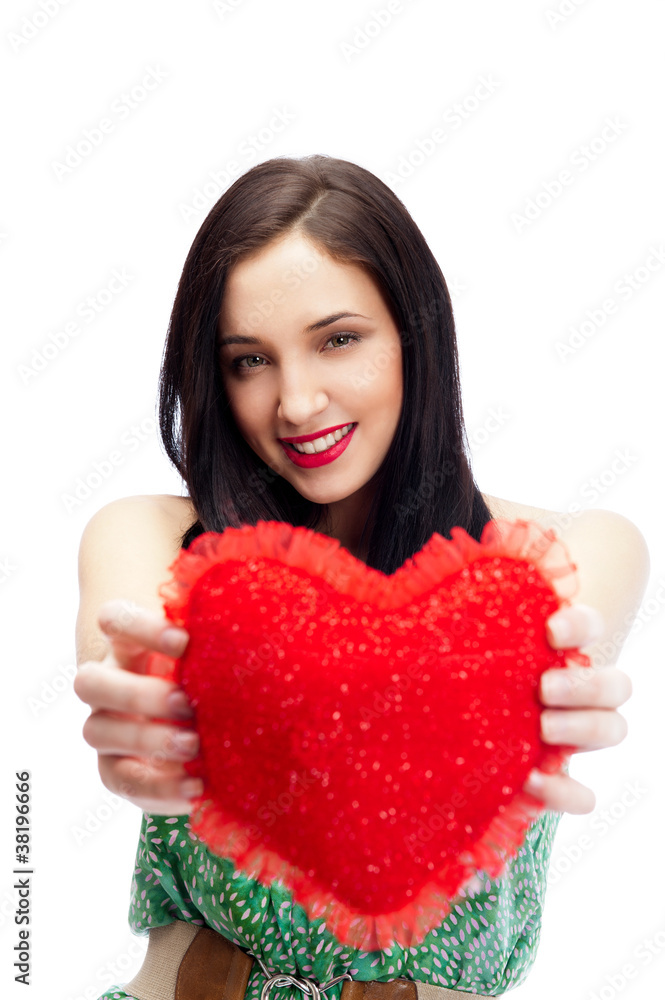 Cute young woman holds a heart symbol isolated on white backgrou Cute young woman holds a heart symbol isolated on white backgrou