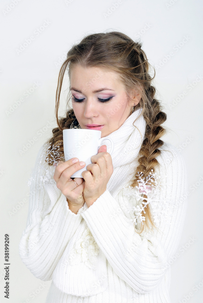 The young beautiful girl in a white scarf with a mug The young beautiful girl in a white scarf with a mug
