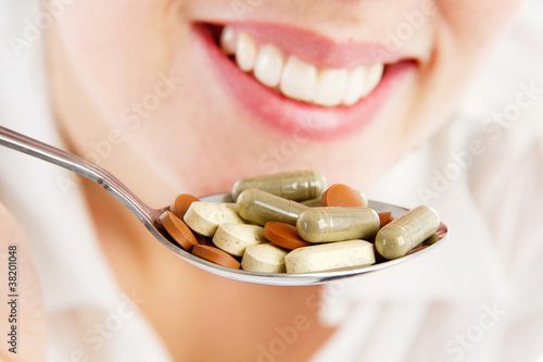 girl holding a spoon full of supplements photo