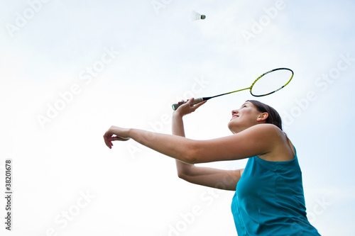 Pretty, young woman playing badminton in a city park © lightpoet