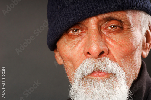face shot of elderly man with grey white goatee