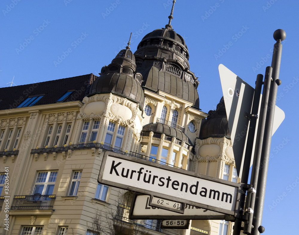 Obraz premium Znak drogowy od bulwaru Kurfürstendamm w Berlinie z zabytkowym domem w tle