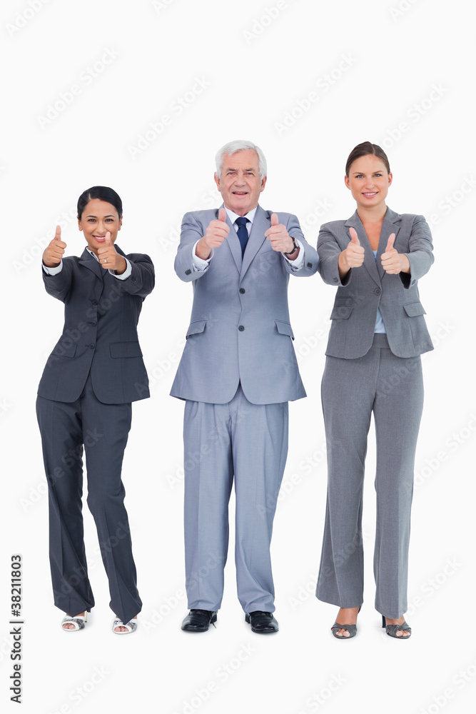 Three smiling businesspeople giving thumbs up Three smiling businesspeople giving thumbs up