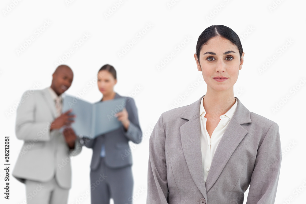 Saleswoman with colleagues behind her Saleswoman with colleagues behind her