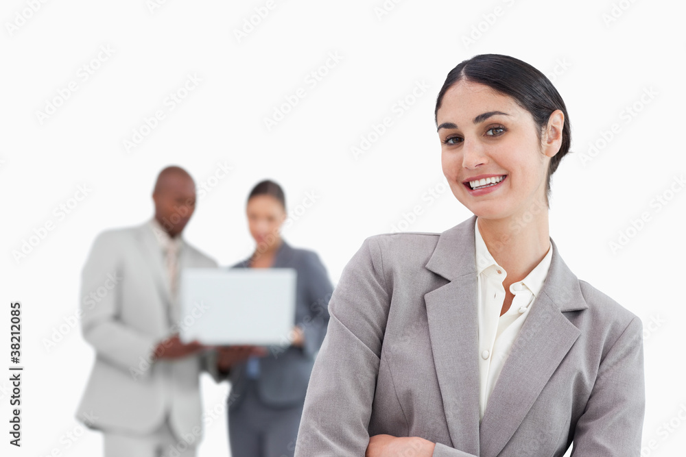 Smiling tradeswoman with colleagues behind her Smiling tradeswoman with colleagues behind her