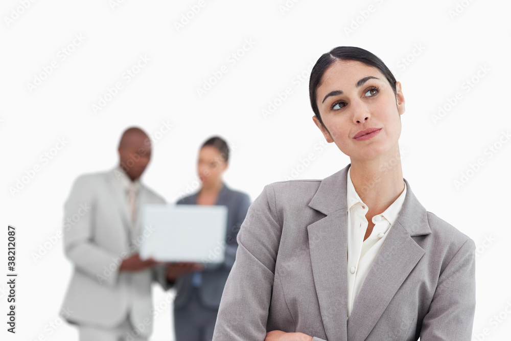 Daydreaming businesswoman with colleagues behind her Daydreaming businesswoman with colleagues behind her