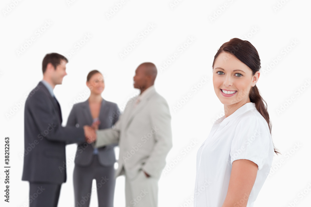 Smiling saleswoman with three colleagues behind her Smiling saleswoman with three colleagues behind her
