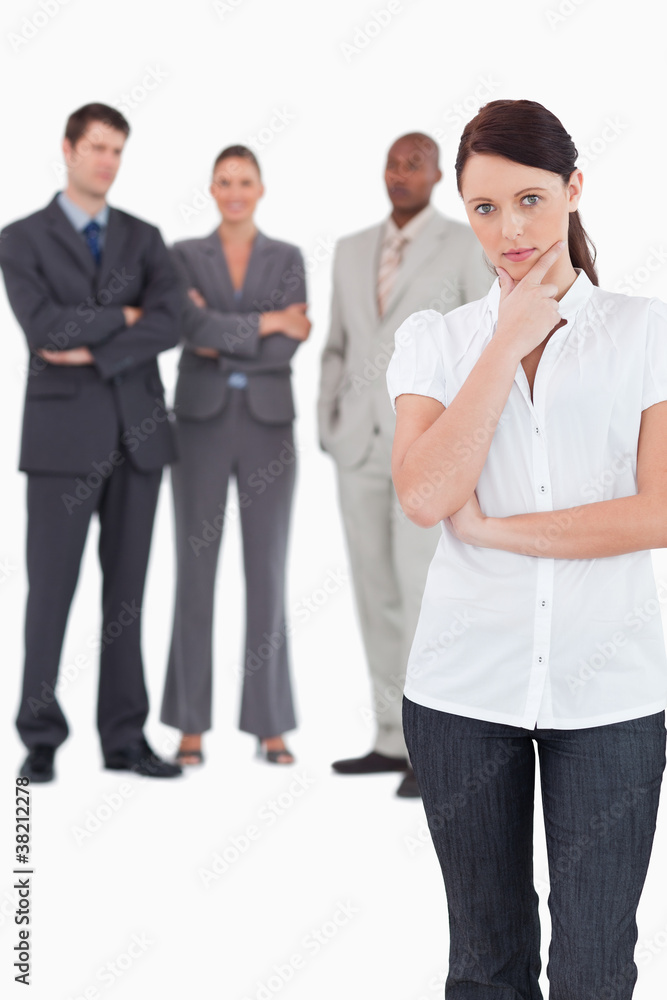 Thinking businesswoman with three colleagues behind her Thinking businesswoman with three colleagues behind her