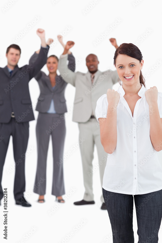 Successful businesswoman with cheering colleagues behind her Successful businesswoman with cheering colleagues behind her