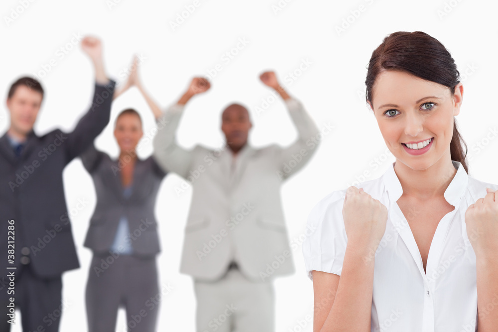 Victorious businesswoman with cheering team behind her Victorious businesswoman with cheering team behind her