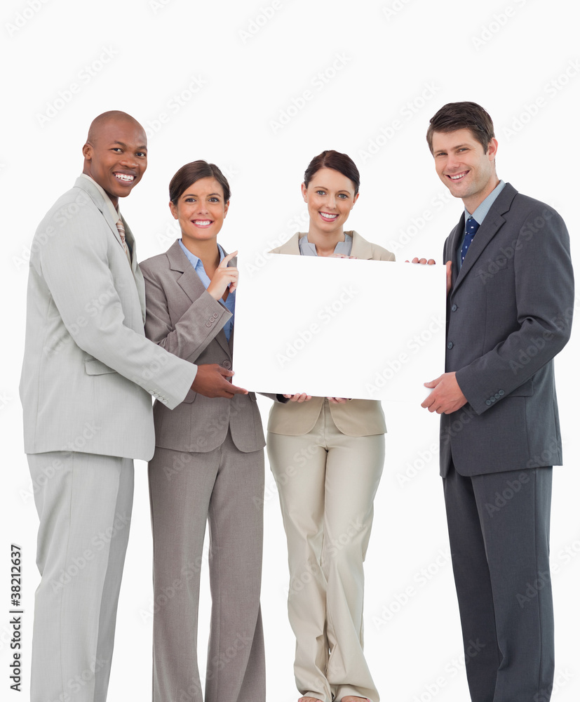 Smiling salesteam holding blank sign together Smiling salesteam holding blank sign together
