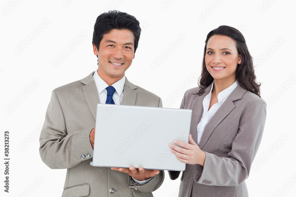 Smiling salesteam with laptop Smiling salesteam with laptop