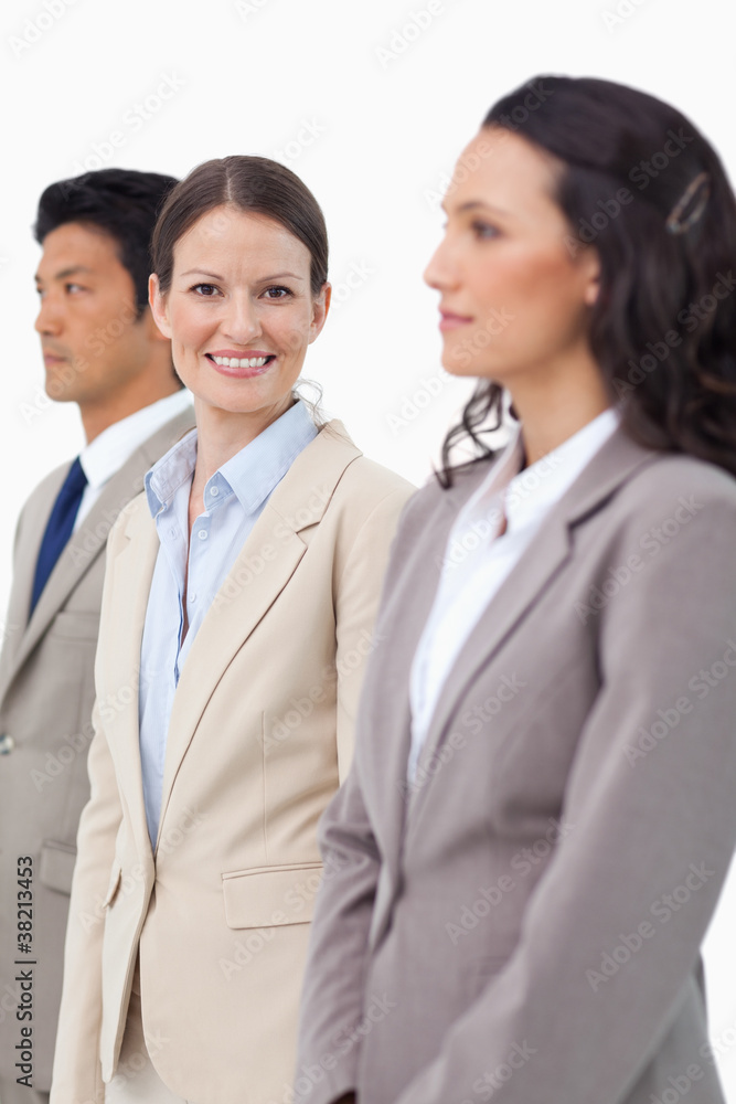 Smiling saleswoman standing between colleagues Smiling saleswoman standing between colleagues