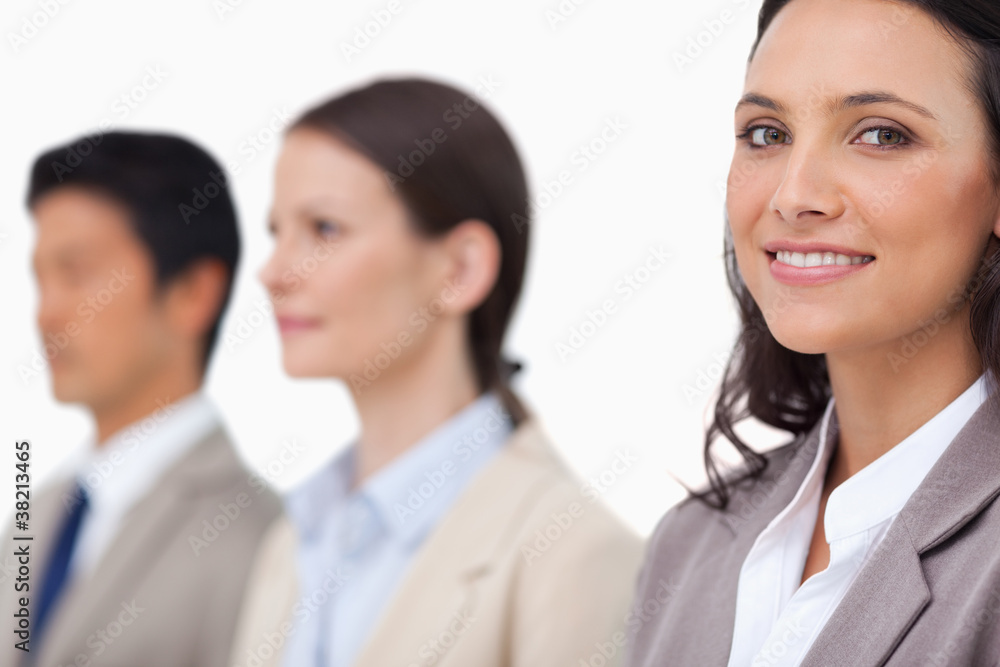 Smiling businesswoman standing next to colleagues Smiling businesswoman standing next to colleagues