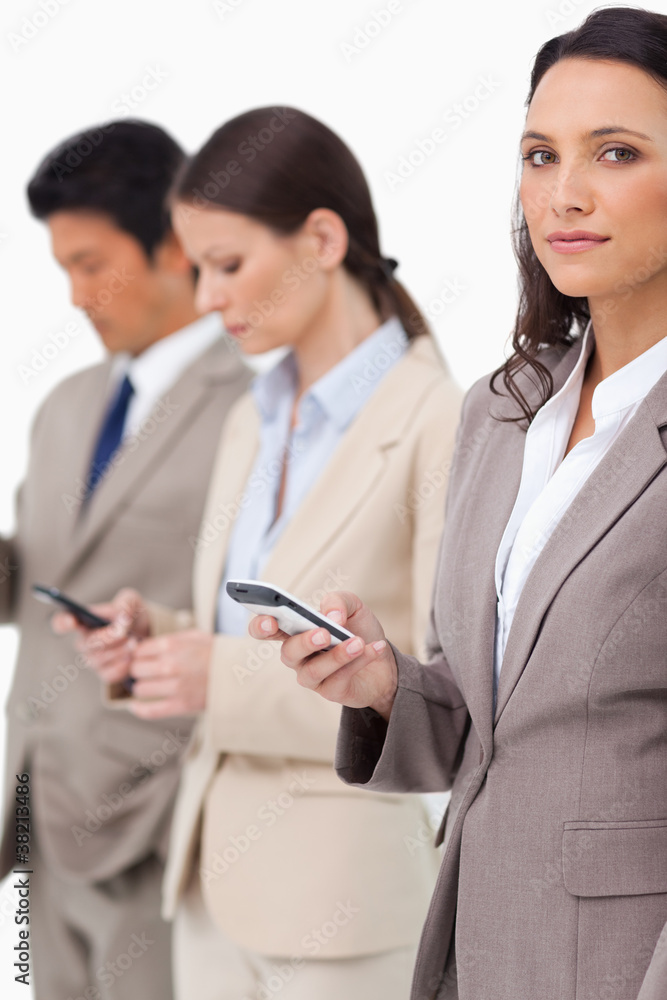 Businesswoman with cellphone next to colleagues Businesswoman with cellphone next to colleagues