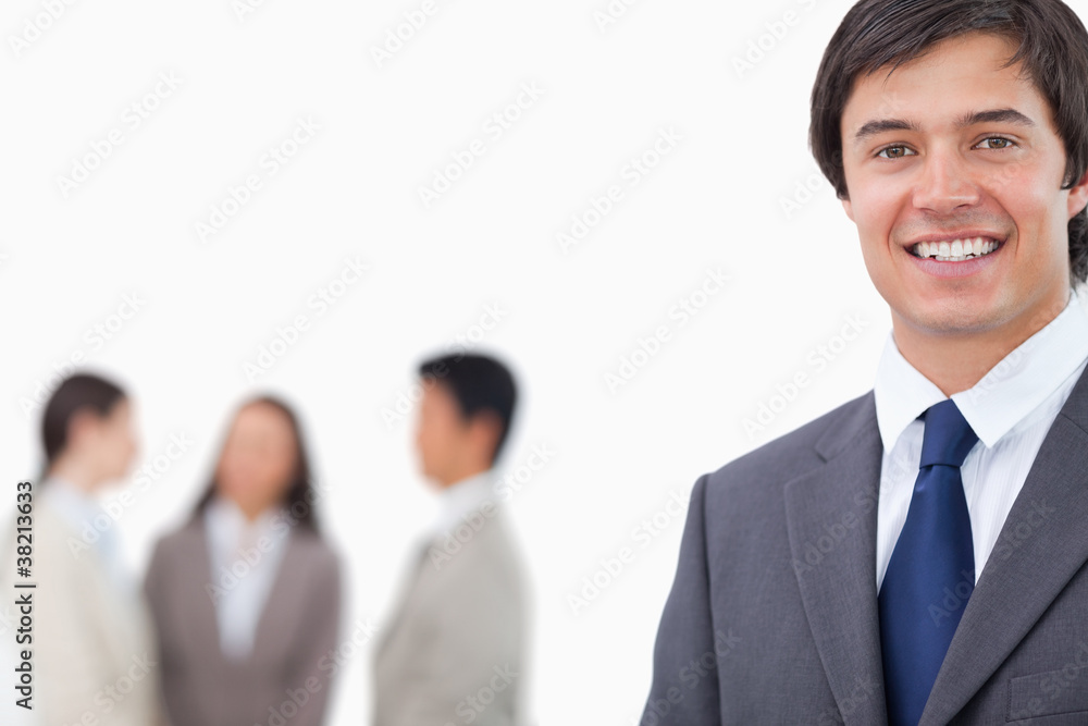 Smiling young businessman with team behind him Smiling young businessman with team behind him