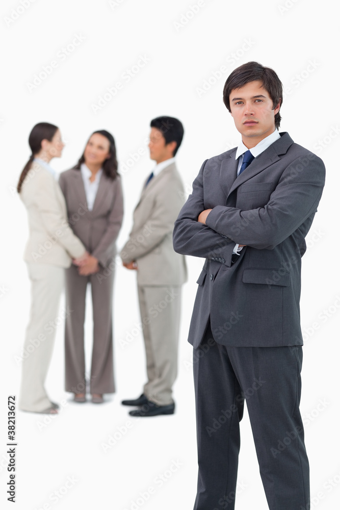 Tradesman with arms folded and associates behind him Tradesman with arms folded and associates behind him