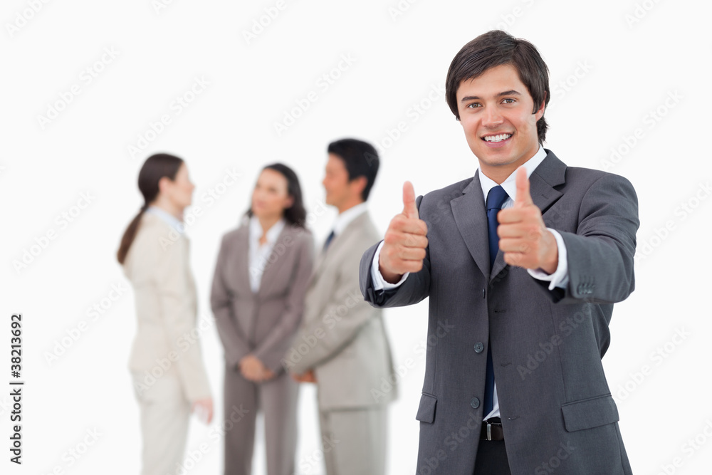 Salesman giving his approval with team behind him Salesman giving his approval with team behind him
