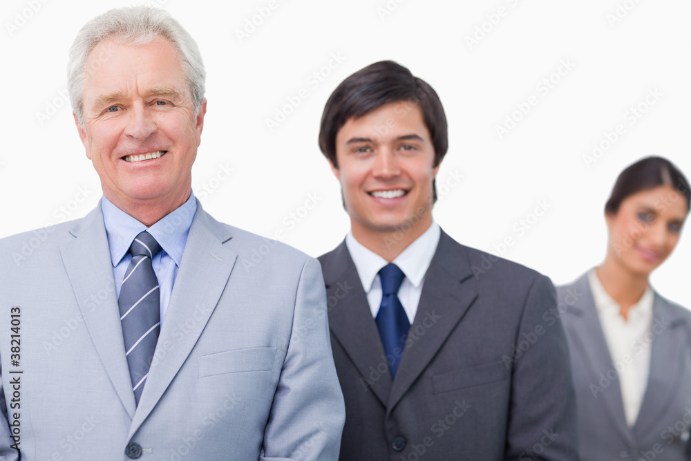 Smiling mature salesman with his employees Smiling mature salesman with his employees