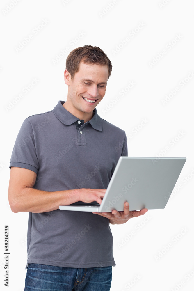 Smiling young man working on laptop Smiling young man working on laptop