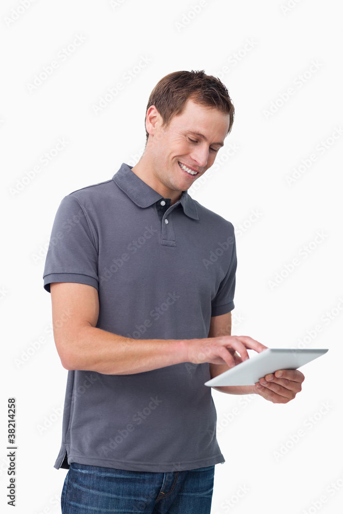 Smiling young man working on his tablet computer Smiling young man working on his tablet computer