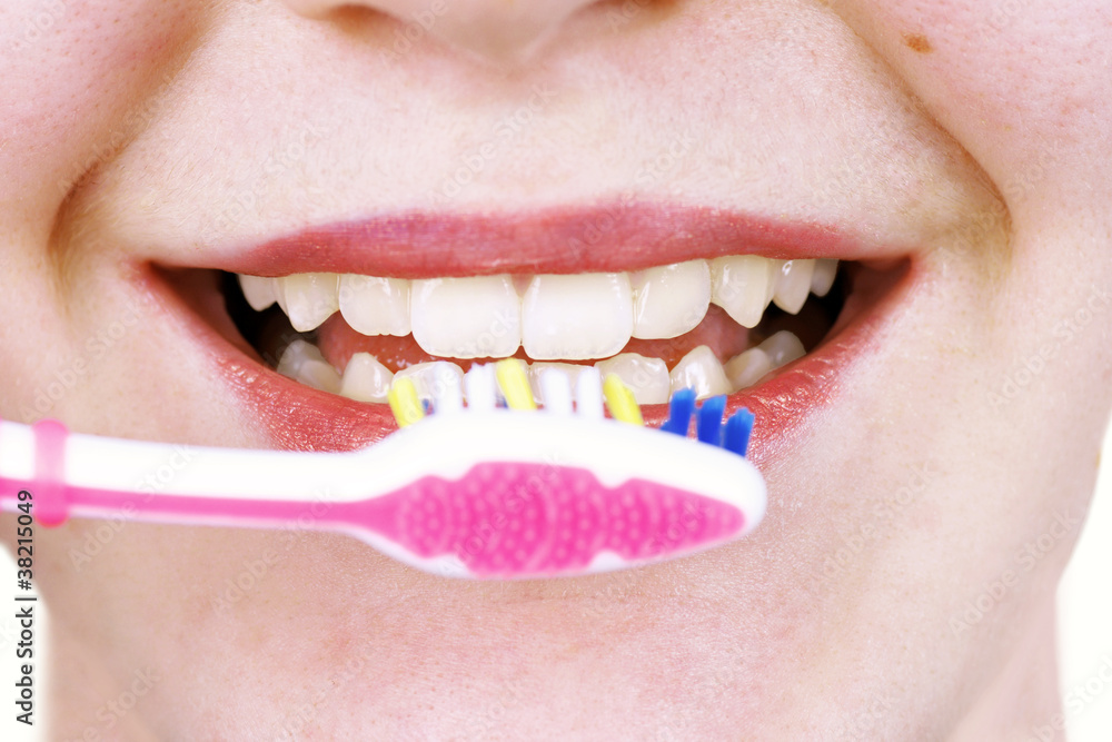Fototapeta premium Young woman brushing teeth