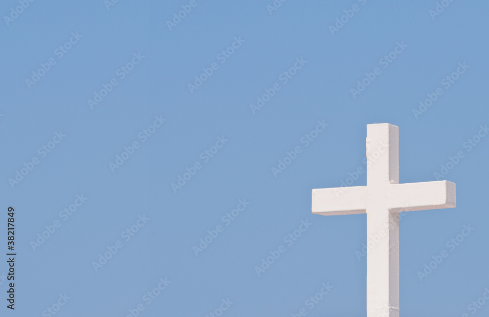 White Christian cross on blue sky