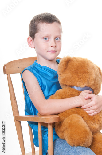 Boy holding bear in rocker photo