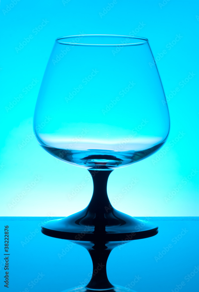 Brandy glass isolated on blue background Brandy glass isolated on blue background