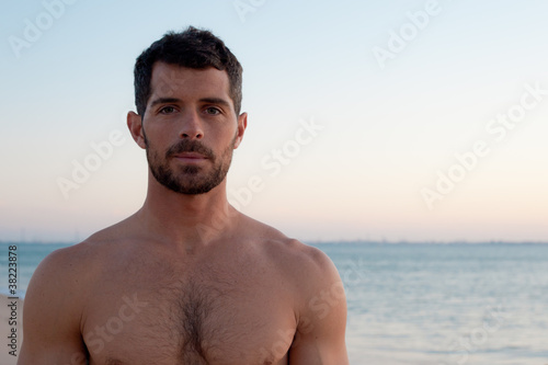 Handsome muscular man on the beach.