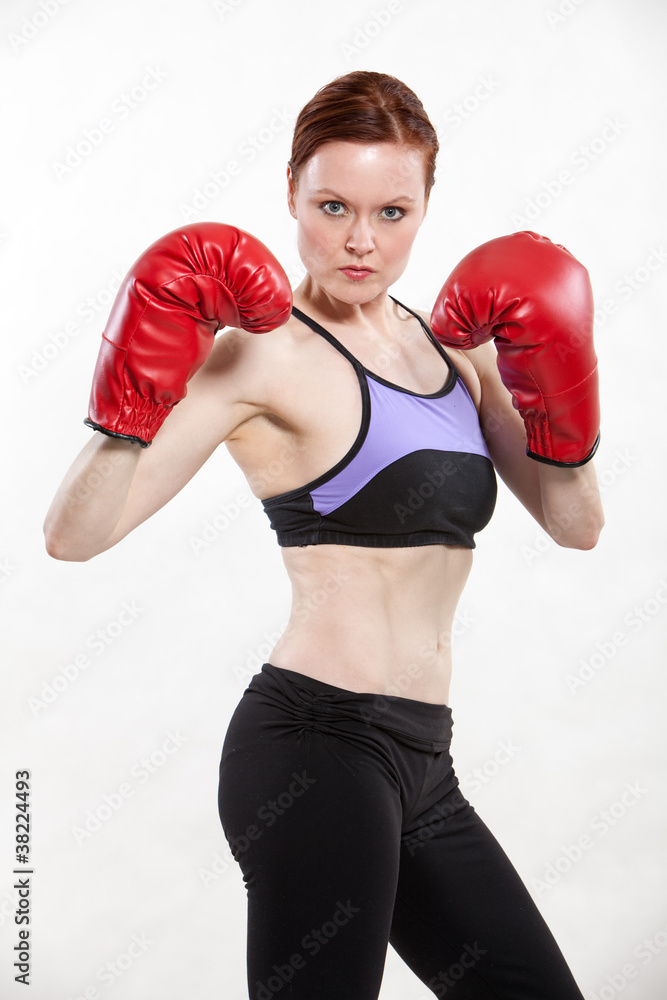 Fit caucasian woman exercising in boxing gloves