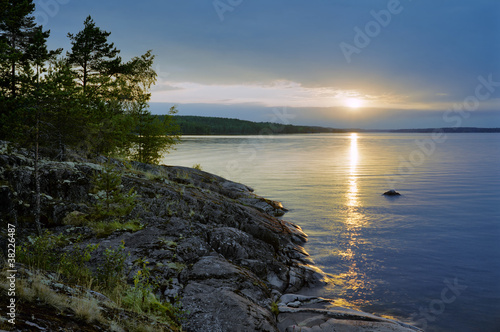 Sunset at stony shore of Ladoga lake, Karelia, Russia
