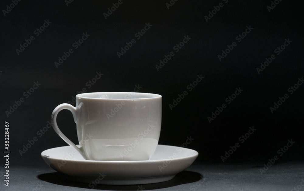 A white cup in front of black background A white cup in front of black background