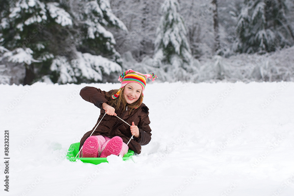 Young girl playing on a snow sled Young girl playing on a snow sled
