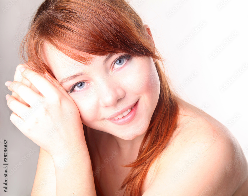 Naklejka premium Sensual young smiling woman with beautiful long red hair
