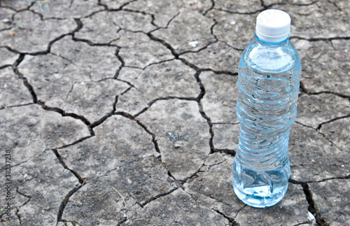Photography Cracked ground with water in a bottle