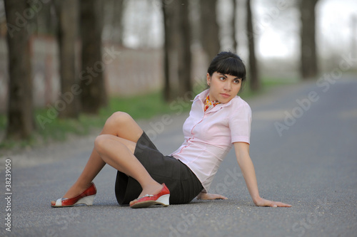 Beautiful girl sitting on a road