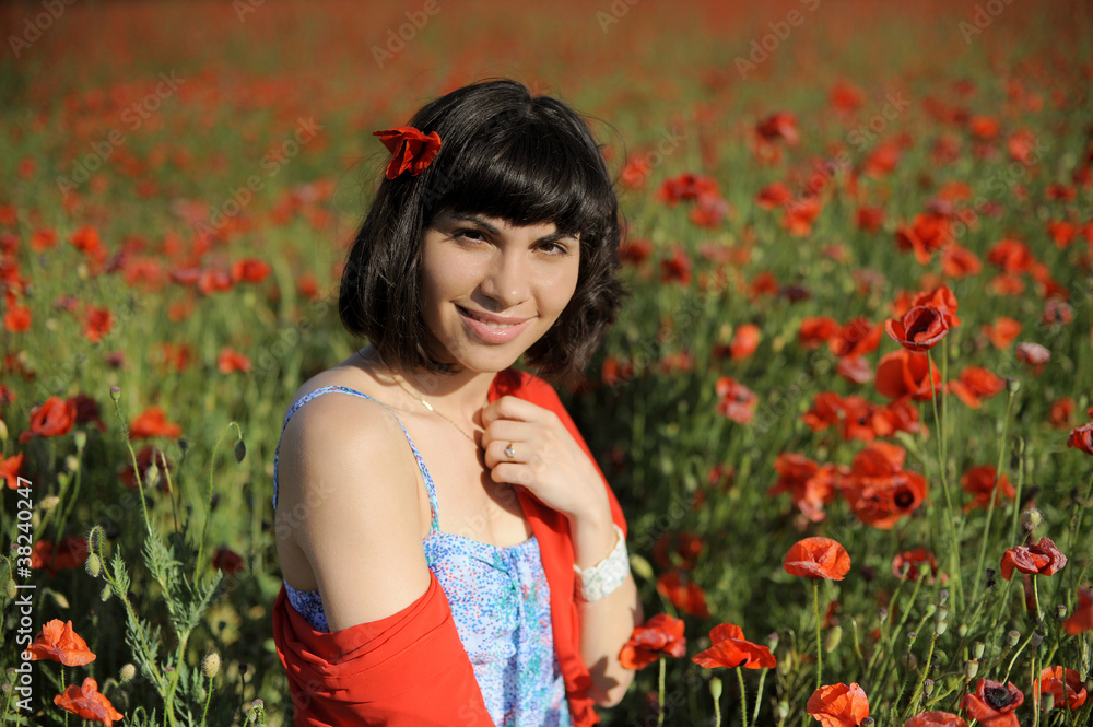 Smiling girl in a red cloth among poppies Smiling girl in a red cloth among poppies