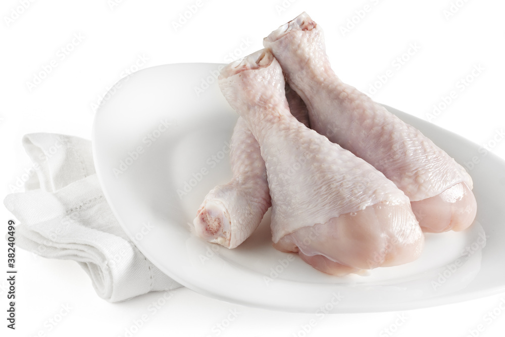 Fresh raw chicken legs on white plate Fresh raw chicken legs on white plate